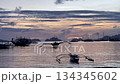 Sunset clouds and a tourist boat swaying in El Nido Bay 134345602