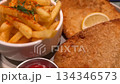 Closeup of breaded schnitzel with fries, ketchup, and lemon slice on a plate video Closeup of breaded schnitzel with fries, ketchup, and lemon slice on a plate video 134346573