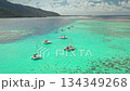 Catamarans are anchoring in shades of turquoise water near the coral reef, with the lush green volcanic mountains of Moorea island creating a stunning backdrop under a bright sky Catamarans are anchoring in shades of turquoise water near the coral reef, with the lush green volcanic mountains of Moorea island creating a stunning backdrop under a bright sky 134349268