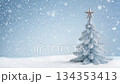 White Christmas tree with a star on top standing in a winter landscape with falling snow. Minimalistic beautiful holiday greeting card 134353413