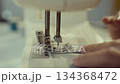 Woman clothing designer sews fabrics on a sewing machine. Needlework and handmade hobby. Selective focus. 134368472