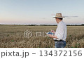 Man in countryside working with a tablet, High-tech solutions for farmers, Innovation in the agricultural sector, Digital transformation in rural areas, Mobile technology for agribusiness, Farmer 134372156
