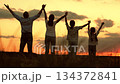 Father lifting child hands up, mother woman holding baby, kids silhouette against sunset, happy family dream scene, outdoor nature meadow, hug and embrace moment, childhood freedom and play 134372841