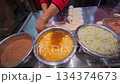 Street Vendor In Asia Is Getting Fillings And Dough Balls Ready Near Egg And Cabbage Bowls For Rapid Service 134374673