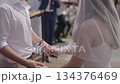 Bride and groom holding hands during jewish chuppah ceremony. 134376469