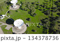 Aerial drone view of large satellite communication antennas in a green rural landscape, representing 134378736