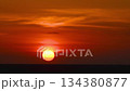 Massive red sun setting over sea 134380877