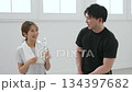 Smiling young woman talking to her personal trainer Smiling young woman talking to her personal trainer 134397682