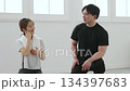 Smiling young woman talking to her personal trainer Smiling young woman talking to her personal trainer 134397683