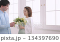 A young couple having a conversation by the window with a bouquet in their hands, and a pregnant woman A young couple having a conversation by the window with a bouquet in their hands, and a pregnant woman 134397690