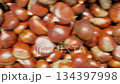Close up view of a pile of fresh chestnuts with shiny brown shells and textured surfaces, creating a natural, organic background ideal for seasonal or food-related themes.. 134397998