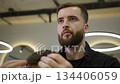 Professional barber styling client's hair in modern barbershop. Clip 134406059