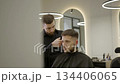Barber giving a haircut with a clipper in a modern barbershop. Clip 134406065