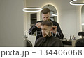 Professional barber giving haircut to client. Clip 134406068
