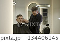 Professional barber cutting client's hair with electric trimmer. Clip 134406145