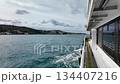 View from ferry deck crossing Bosphorus Strait in Istanbul, Turkey with coastal cityscape and hills under cloudy sky 134407216