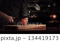 A chef with a very sharp knife cuts off a piece of tomato for a burger in one move. High quality 4k footage 134419173