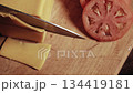 Chef cuts a thin piece of cheese with a sharp knife on a wooden cutting board. Top view close-up high quality 4k footage 134419181