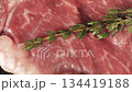 Juicy fresh piece of meat with sprig of rosemary frying on a hot grill pan. Cooking delicious steak at home. Close-up high quality 4k footage 134419188