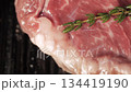 Top view on juicy rib eye steak with rosemary branch frying on a hot grill pan. Cooking delicious steak at home. High quality 4k footage 134419190