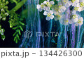 White blooms with emerald tendrils and falling glitter, vibrant green ribbons and luminous particle trails 134426300