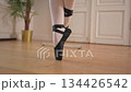 Ballerina practicing ballet positions dancing in dance class, pointe shoes close up. Ballet pointe shoes on feet in dance studio class. Classical ballet dancer woman in dance studio. Ballet school 134426542