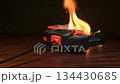 A controller connected to a wire is engulfed in flames - a conceptual photo depicting a malfunction and fire hazard 134430685