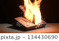 A landline phone is engulfed in bright flames and sparks during a fire. Concept of electronics malfunction and fire risk 134430690