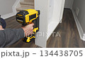 Handheld power tool is being used to secure wooden panels together in a home improvement project, showcasing the assembly process step by step 134438705