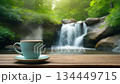 A relaxing loop video of a waterfall and steaming coffee in a forest in early summer 134449715