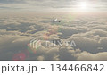 Passenger Airplane Above the Clouds Flying Off Into A Beautiful Sunset. 134466842
