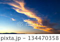Scenic time-lapse of golden sunset clouds moving across the deep blue starry twilight sky 134470358