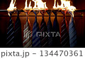 Medium shot of a row of colorful striped neckties on fire in a wooden closet 134470361