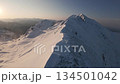 FPV drone flies up snowy alpine ridge at dawn 134501042