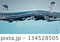 Slow motion water droplets falling and creating dynamic splash ripples in crystal clear blue liquid with underwater bubbles 134528505