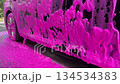 Thick pink foam car wash soap covering vehicle surface at self service car washing station cleaning dirt 134534383