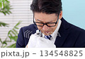 A man examining something with a magnifying glass 134548825