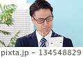 Man wearing white gloves holding a calculator 134548829