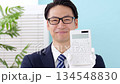 Man wearing white gloves holding a calculator 134548830