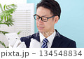 Man wearing white gloves holding a calculator 134548834
