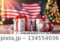 Festive holiday gifts with red bows and ornaments in foreground, American flag backdrop, camera gradually zooms in on scene details and decorations 134554036