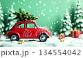 Red toy car with Christmas tree on top drives through snowy landscape, camera pans to capture festive atmosphere and holiday spirit 134554042