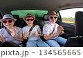 Happy kids, boy girl, traveling having fun in car. Summer trip with their parents. Group of children in sunglasses are riding in car, dancing having fun. Family car trip with children during holidays 134565665