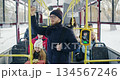 Front view of people going by public transport. Passengers on bus, boy with glasses and rucksack standing, girl with gift box sitting, old man in red jacket. Concept of routine. 134567246