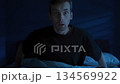 Fearful man suddenly wakes up in a panic attack. Sleep disorder and night terror 134569922