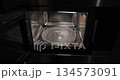 Heating food in a microwave oven, open door 134573091
