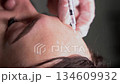 Beautician doctor makes botulinum toxin injection in the forehead of young beautiful woman. Close up vertical 4k shot 134609932