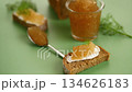 Fresh fish caviar arranged on spoon and bread over soft green background 134626183