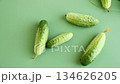 green fresh cucumbers with leaves on a green background 134626205