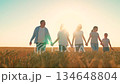 Farm family, children, parents walk together. Group people. Parents raising kids. Happy farm family with children strolls through wheat field. Father mother, daughter walk hand in hand in wheat field 134648804